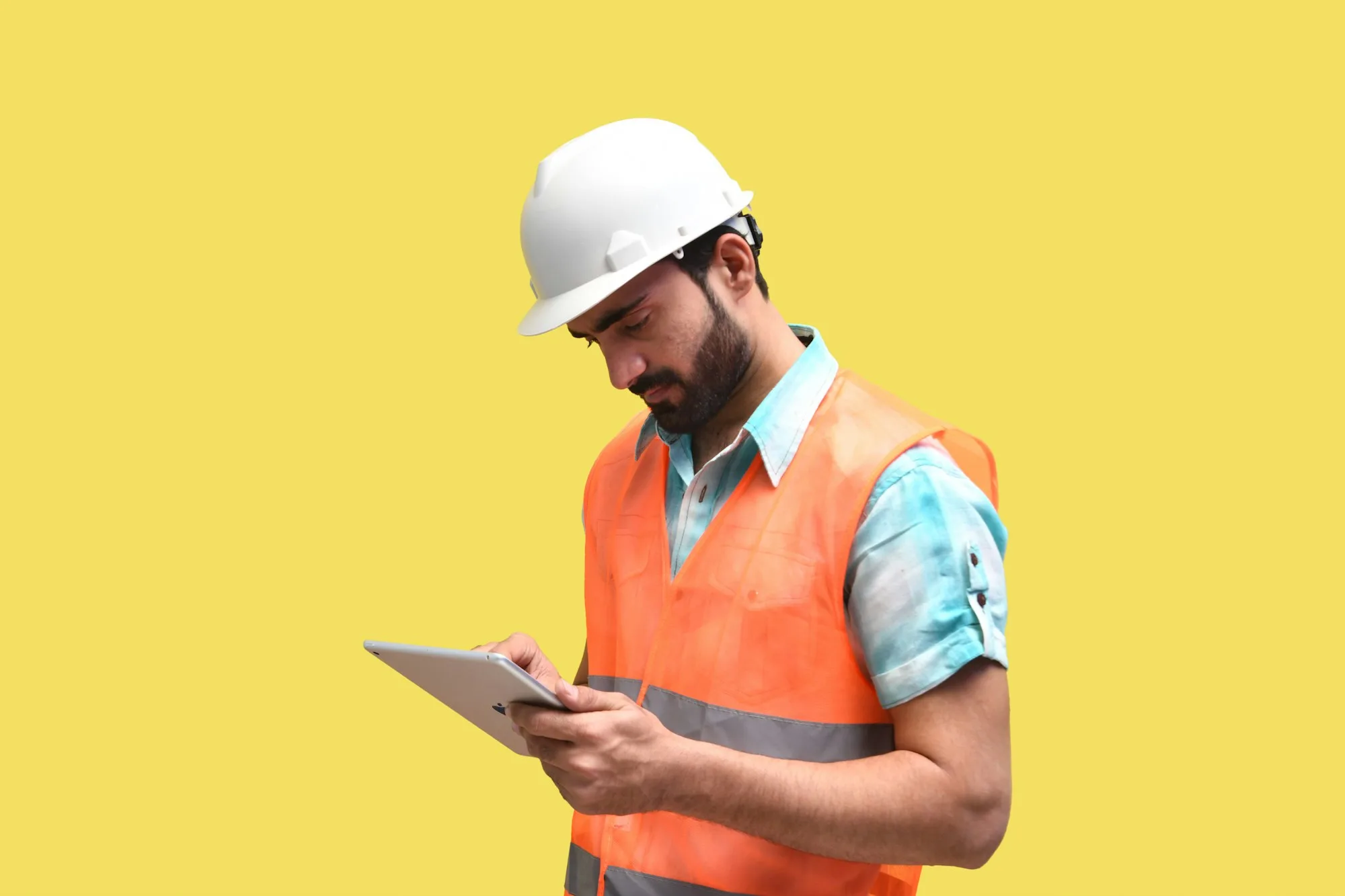 Two engineers reviewing site work on a tablet in the field
