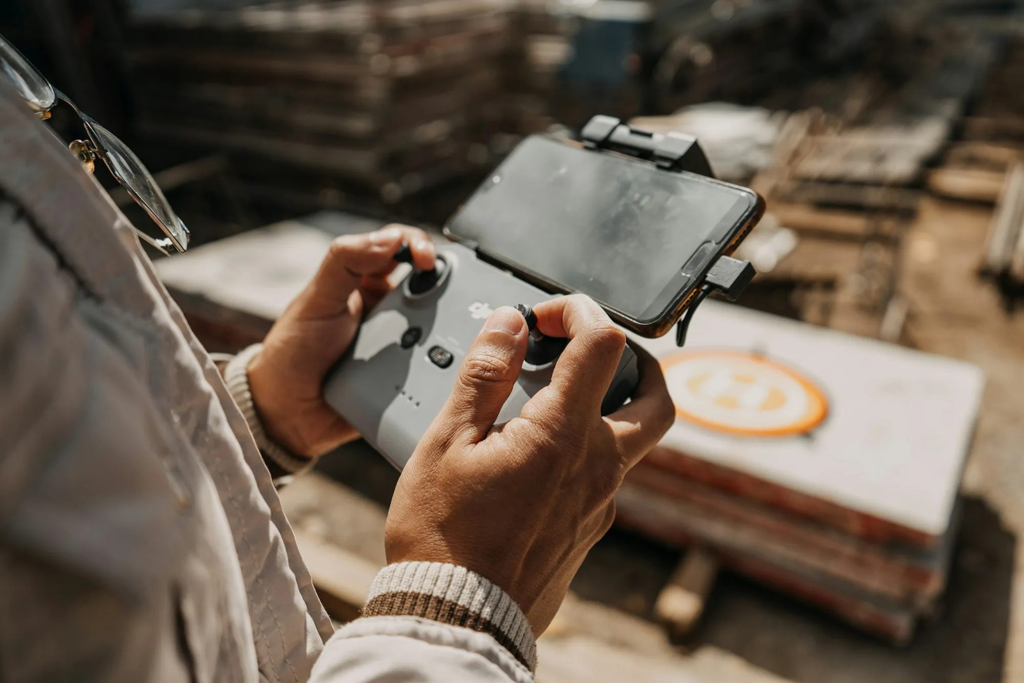 An engineer holding a tablet that shows a building blueprint, on an active site